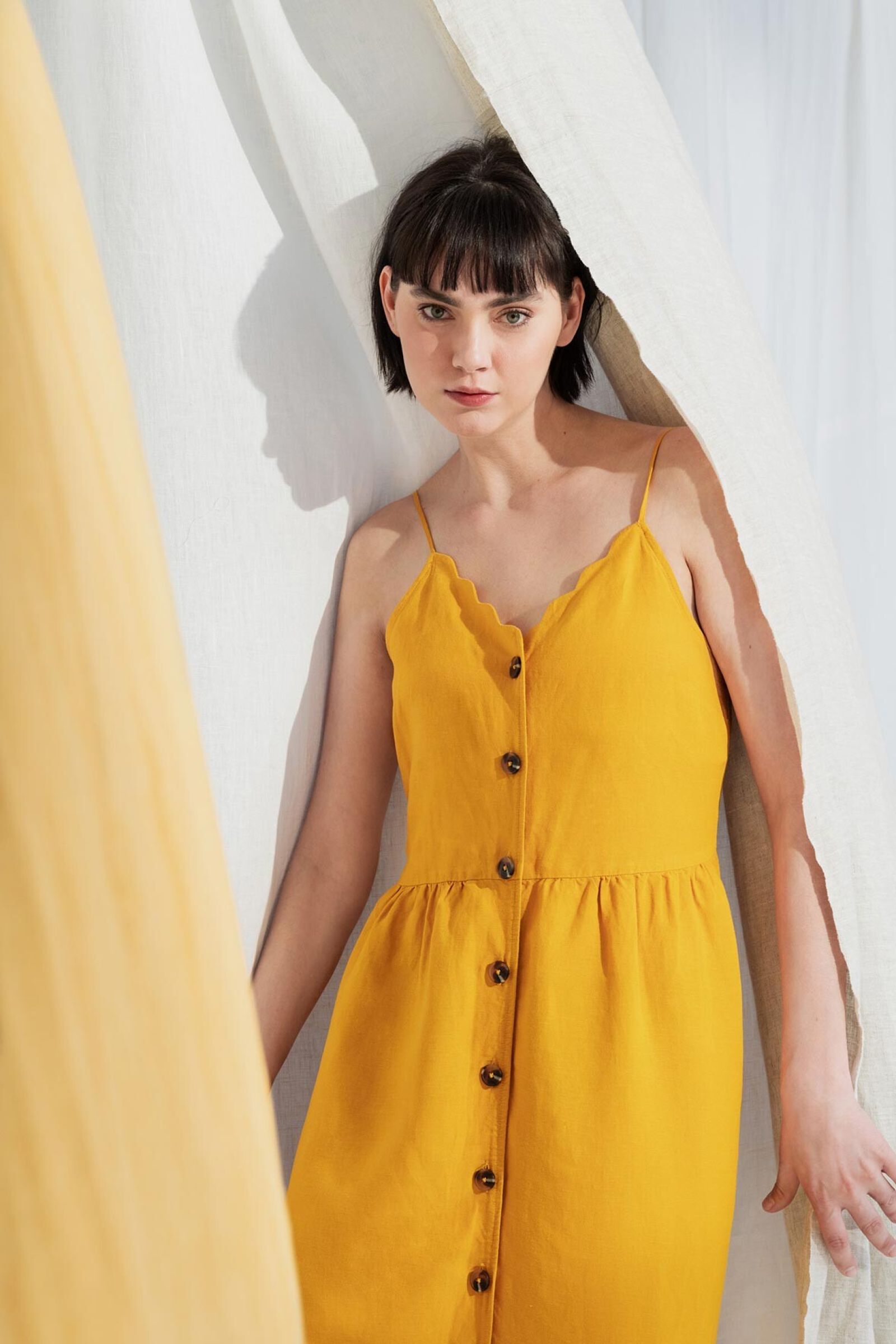 Model in gelbem Kleid zwischen Leinentüchern; Filmproduktion Düsseldorf